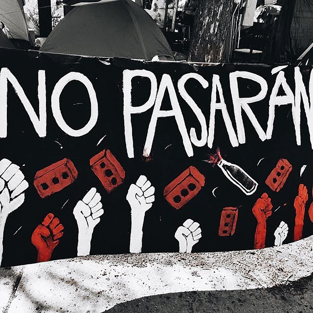 Hand-painted protest banner reading 'No Pasarán' with raised fists and Molotov bottles in red, white and black
