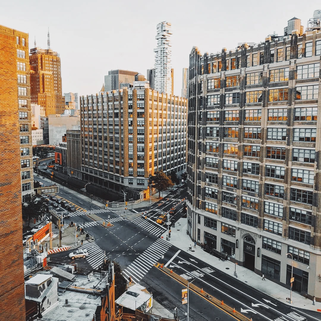 Aerial view of a busy New York City intersection with construction scaffolding and pedestrian crossings